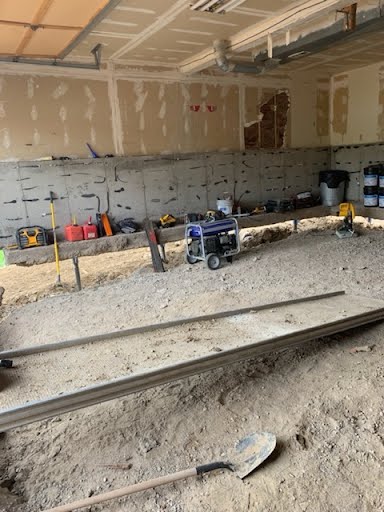 Excavated soil pits under a garage footing where steel piers will be installed