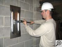 Attempting to straighten a bowed foundation wall by straightening a wall anchor system in a Steamboat Springs home.