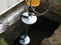 Installing a helical pier system in the earth around a foundation in Montrose