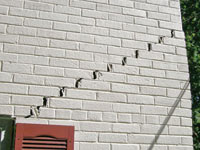 Stair-step cracks showing in a home foundation in Silt